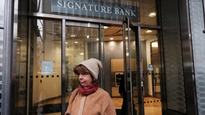 A woman walks out of a Manhattan branch of Signature Bank, which was closed by bank regulators one day before, on March 13, 2023 in New York City. 